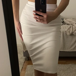 Vit midikjol - Åtsittande midikjol i vit, justerad i midjan