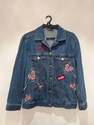 Jeansjacka  - Snygg och cool jeansjacka i mycket bra skick. En jacka i tvättad denim med broderier och broderade applikationer. Storlek 38 men är stor i storleken. 