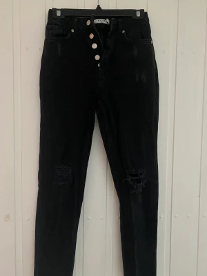Mom jeans - Svarta mom jeans från NA-KD. Hål och sliten design. Knappt använda