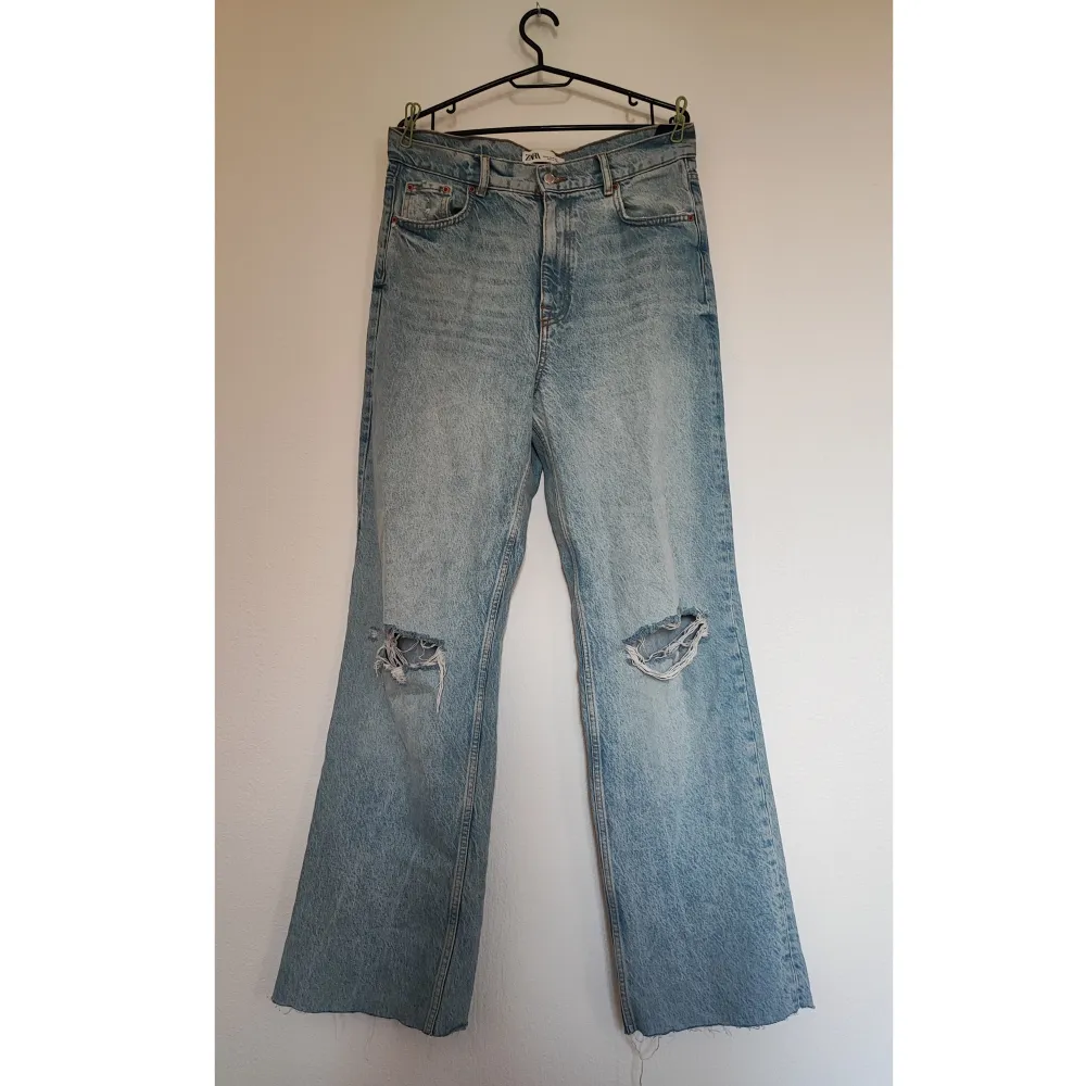 Supersnygga ljusa jeans med slitningar. Hög midja och vida benslut. Midjemått: 88 cm. Mycket fint skick.. Jeans & Byxor.