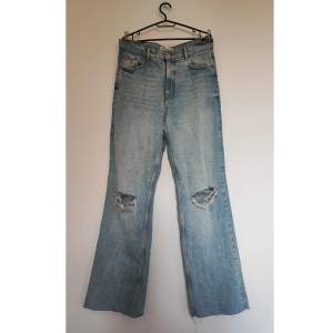 Supersnygga ljusa jeans med slitningar. Hög midja och vida benslut. Midjemått: 88 cm. Mycket fint skick.