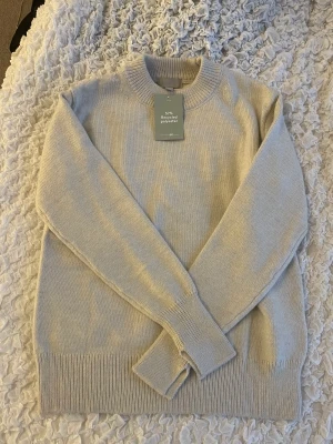 Stickad tröja - Beige/Vit skön stickad tröja, ej använd , med prislapp