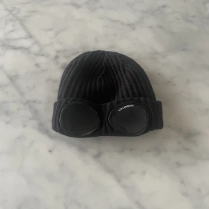 Cp company mössa - En mössa som är använd cirka tio ggr och i bra skick förutom att den är skrapad på ena glaset 