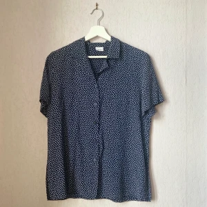 Skjorta & kjol, set  - Ett set med skjorta och kjol, blå med vita prickar. Inga defekter, båda delarna är i mycket gott skick. Stilren passform. Okänt märke.