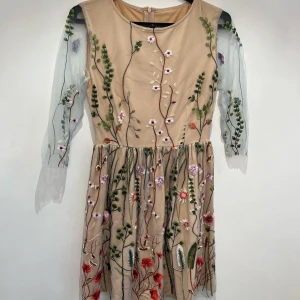 Klänning  - En jättefin klänning i transparent mesh med broderier. 