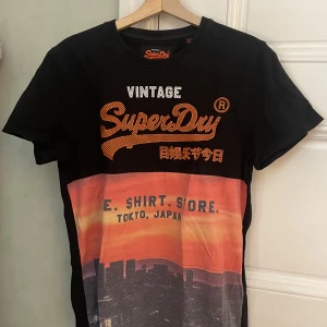 T-shirt från superdry svart/orange - Tröja med tryck från Superdry. Små Tecken på användning men övrigt mycket bra skick! 