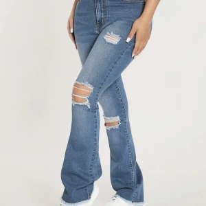 Blåa jeans med slitningar - Blåa jättefina jeans med slitningar. Aldrig använda då den är för små för mig 