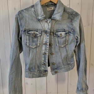Jeansjacka  - Ljus blå, kroppad jeansjacka med ”vintage” stil. Från Lindex, fint skick.