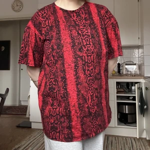 Röd t-shirt från motel  - T-short i rött och svart ormprint. I nyskick och luftig i materialet. Använd som klänning på mig som är 168cm men marknadsför på orginalhemsida som t-shirt.   100% bomull