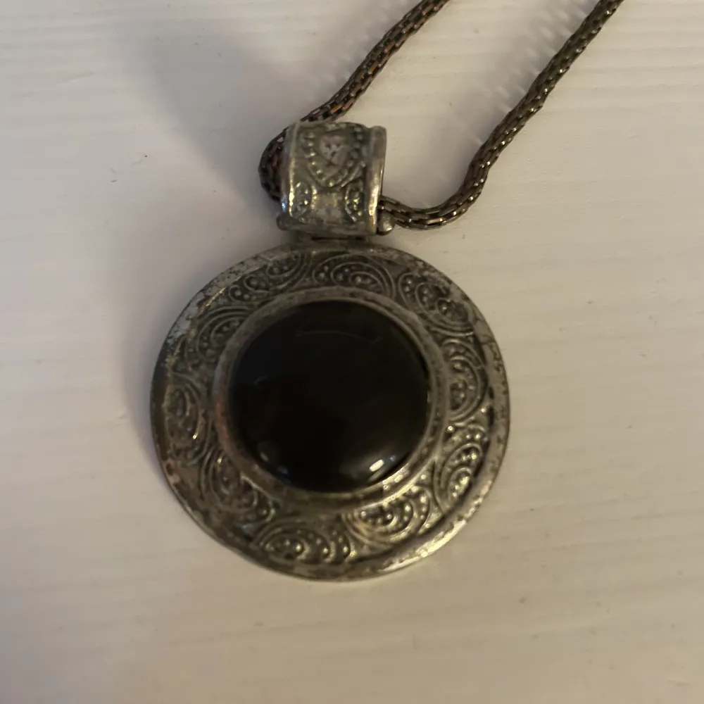 Ett halsband i bronsaktig färj med ett fint smycke på i silver och svart! Super unikt❤️. Accessoarer.