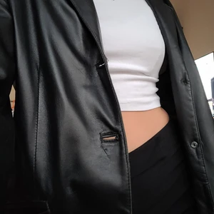 Svart läder kappa - Svart läder kappa i bra skick. Svin cool och passar till nästan allt. Finns vissa små slitningar. Verkligen tyckt om den. Jag tror inte att den är äkta läder. Funkar jätte bra som höstjacka med en tröja under. Verkligen fin och i bra skick. 