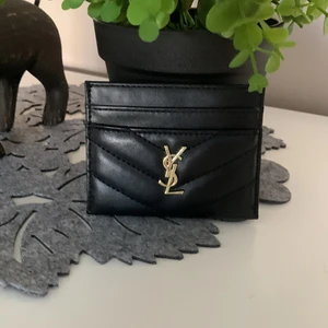 Ysl svart skinn med guld märke kop - Säljer min svarta korthållare ysl i skinn kop men mkt bra kvalite och så fint mjukt skinn. 