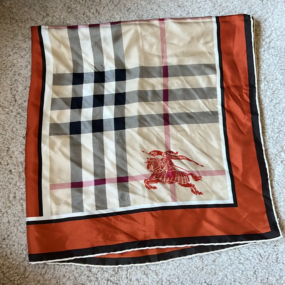 En sjal från burberry som går att vika och använda som topp. Mäter 66x66 cm. En burnt orange färg med rosa/rött, svart och beigt rutmönster. . Accessoarer.