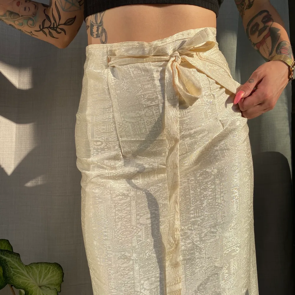 • Wrap-Around kjol i thai silke • Fin kvalitet och i bra skick. Vacker vaniljfärg med mönster i tyget. Räcker ner till anklarna mina.. Kjolar.