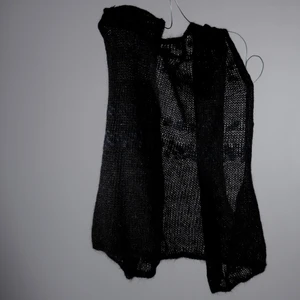 Stickad svart väst - One-of-a-kind stickad väst i svart. Stickad av Röda Korsets-stickgrupp i Västerort tillsammans med Ebba Martin. Alla pengar från budgivningen går oavkortat till Röda Korsets arbete för att hjälpa människor i kris och katastrofer.