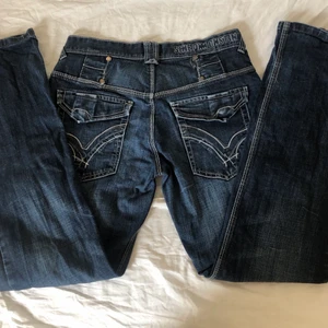 Lågmidjade bootcut jeans - Lägger upp igen eftersom föra köparen hoppade av. Super snygga mörkblå lågmidjade bootcut jeans med vita detaljer. Bara att höra av er om ni har frågor eller vill ha fler bilder. 500 kr+frakt🌸 INGEN BUDGIVNING FÖRST TILL KVART SOM GÄLLER!!!