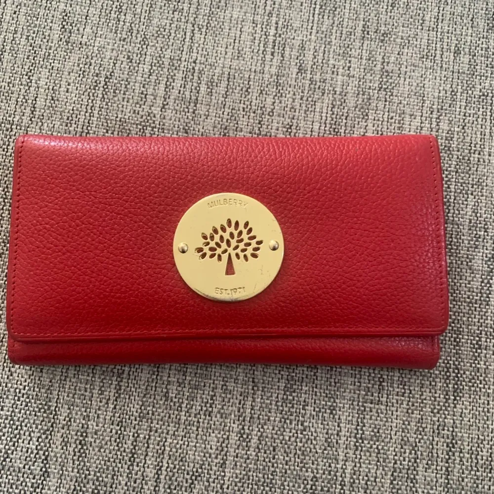 Röd Mulberry plånbok med många fack för kort inklusive ett fack med dragkedja. Skickas spårbart med Postnord. Väskor.
