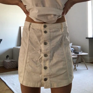 Vit jeanskjol med knappar - En vit jeanskjol med knappar som kan bäras både highwaisted men även lite längre ner. Det finns några få små tecken på att den är använd, men inget man tänker på. 