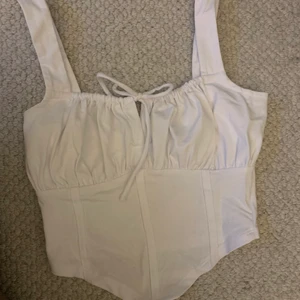 Vittopp  - Vitt linne, korsett linkande. Storlek 34. Köpare står för frakt. 
