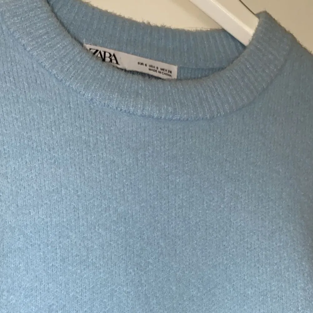 Superfin blå stickad tröja från zara som är lite ”fluffig” i materialet, tröjan är lite kortare i modellen. Aldrig använd så den är precis som ny! . Stickat.