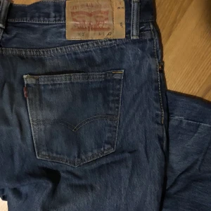 Blåa levis jeans - Mörkblå original 501 Levi’s jeans, ganska baggy, lågmidjade med knappgylf. Använt skick utan hål eller nötningar. Midjemått: 93cm  Längd: 105cm
