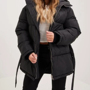 Vinterjacka - Svart vinterjacka med snöre i midjan. Köptes i mars 2022 så inte använd mycket alls. Strl 38