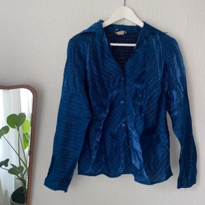 Blus i blå mesh - Så cool blus i ett så vackert tyg! Den är glansig och i mesh, men inte genomskinlig. Sitter figursytt men inte tight, på mig som vanligtvis är strl S.