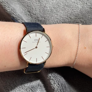 DW klocka  - Guld klocka med marinblått band, finns en liten repa, men knappt syns. Klockan funkar jätte bra.