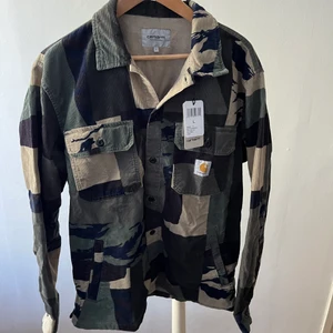 Carhartt jacka, oanvänd - Carhartt camouflage jacka - L, 850  Passar mig som är 182 och väger 83 kg. Köparen står för frakt.