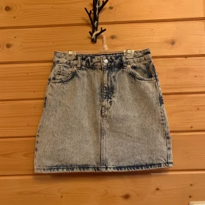 Jeanskjol - En fin jeanskjol i 100% bomull och riktiga fickor fram och bak! Färgen är ljus denim med en sliten effekt, använd 1 gång. 