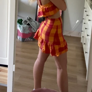 Matchande kjol och topp  - Orange och rödrutig kjol och topp. Lågmidjad kjol som är snedskuren 