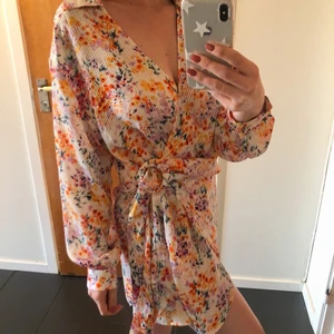 Blommig plisserad klänning  - Blommig plisserad klänning från H&M, storlek M. Aldrig använd. 