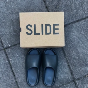 Adidas yeezy slides ”Onix” 43” - Ett par nyvunna Adidas yeezy slides från deras utlottning som gjordes på deras egen app ”confirmed”. Säljs för att de är för små för mig, och är storlek 43. Helt oanvända. 
