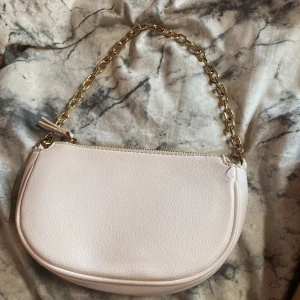 Axelremsväska  - En vit/beige väska från mango, guldig kedja.  