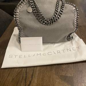 Säljer min väska från Stella MC, det är en Falabella mini tote i färgen light grey. Använd få gånger, i mycket gott skick/ som ny. Köpt 2018 kvitto finns. Ny pris på hemsida 8640kr
