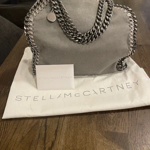 Stella McCartney Falabella väska  - Säljer min väska från Stella MC, det är en Falabella mini tote i färgen light grey. Använd få gånger, i mycket gott skick/ som ny. Köpt 2018 kvitto finns. Ny pris på hemsida 8640kr