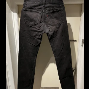 Levis 501 - Vintage svarta levis med lite röd ton i. Storlek w31L34. Lite slitet på ena knä. Skriv för bild. Skriv om ni undrar något. Kan samfrakta också.