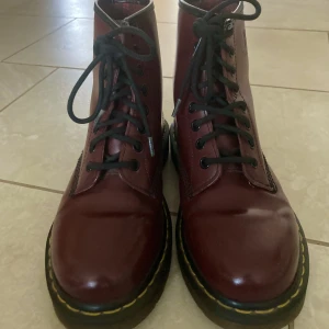 Nya vinröda Dr. Martens  - Äkta vinröda Dr. Martens i nytt skick. Snygga och trendiga, perfekta för stundande vinter/vår. Använda max 5 gånger. Orginalpriset är 1600 kr. Storlek 37.   Kan både frakta och mötas upp. Kan skicka fler bilder vid intresse. 😊
