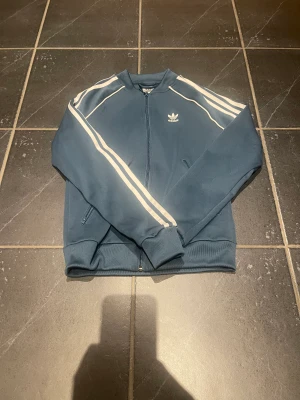 Tröja - En ziptröja i färgen Petron, storlek Si junior. Nästan oanvänd och i väldigt fint skick. Nypris 499 kr. 