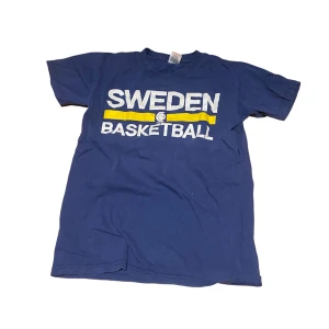 Mörkblå basket t-shirt - Storlek S. Har tyvärr ett pyttelitet hål (se bild 2), men inget man tänker på mycket. Går annars sy med ett stygn typ.