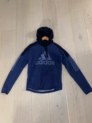 Adidas Hoodie - Säljer nu en blå adidas hoodie då den inte kommer till sin användning längre. Den är i mycket fint skick och har inga tydliga tecken på användning. Tröjan är i storlek S Vid eventuella frågor eller funderingar är det bara att höra av sig! Kan samfrakta!