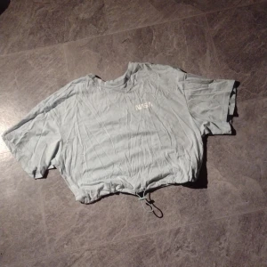 T-shirt - Ljusblå t-shirt med tryck på ryggen. Aldrig använt, så är i fint skick. Strlk xs