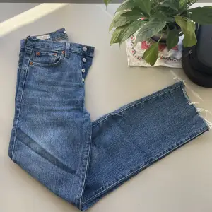 Knappt använda Levis jeans midjemått 25. Fransar i benen och hög knapp-midja