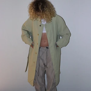 Kappa/Trenchcoat - Min absoluta favoritkappa som jag nu tyvärr tröttnat på. Färgen är ljusbeige/grön. Något ljusare än på bilden. Väl använd. Sitter SÅ snyggt. 