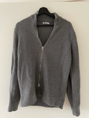 Zara stickad tröja - Säljer min gråa tröja från ZARA då den inte kommer till användning längre. Den är ribbad och i storlek M. Passar mig som brukar ha S i vanliga fall. Snygg att ha över en skjorta, t-shirt eller liknande.