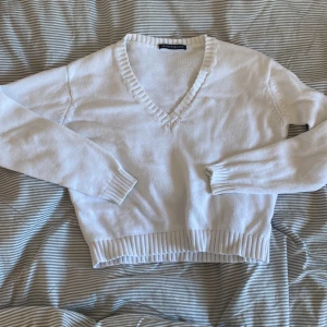 Vit stickad tröja - En vit v-ringad tröja från brandy melville, är i fint skick. Är i onesize men skulle säga att den är som en xs