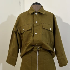 Denim jacka i khaki - Weekday denim oversizejacka i mycket gott skick, använd ca 5 gånger.   Går även att köpa i set tillsammans med matchande kjol till lägre pris! (se min profil)