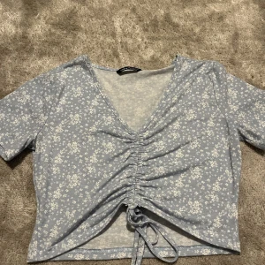 Topp - Blommig topp i ett skönt material. Magtröja 
