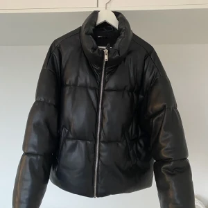 Jacka - Pufferjacket med läderimitation från Gina Tricot. Köparen står för frakt eller möts upp i Göteborg. Passar mig som är en M bra.
