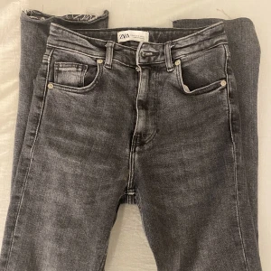 Zara jeans stl 32 - Säljer ett par gråa zara jeans i storlek 32, supersnygga med slits nedtill 